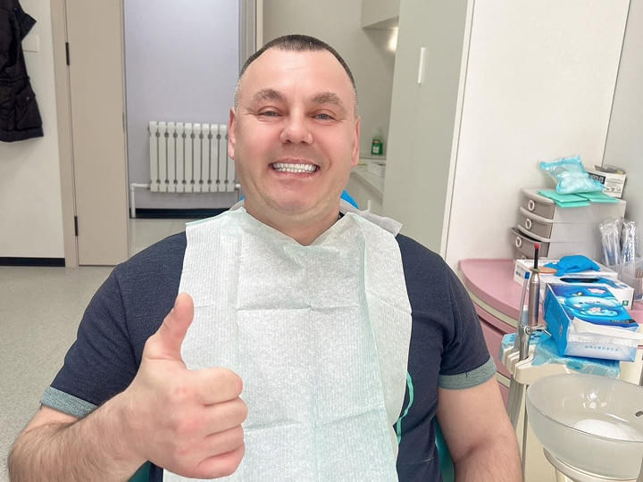 Улыбающийся пациент после лечения зубов в Китае